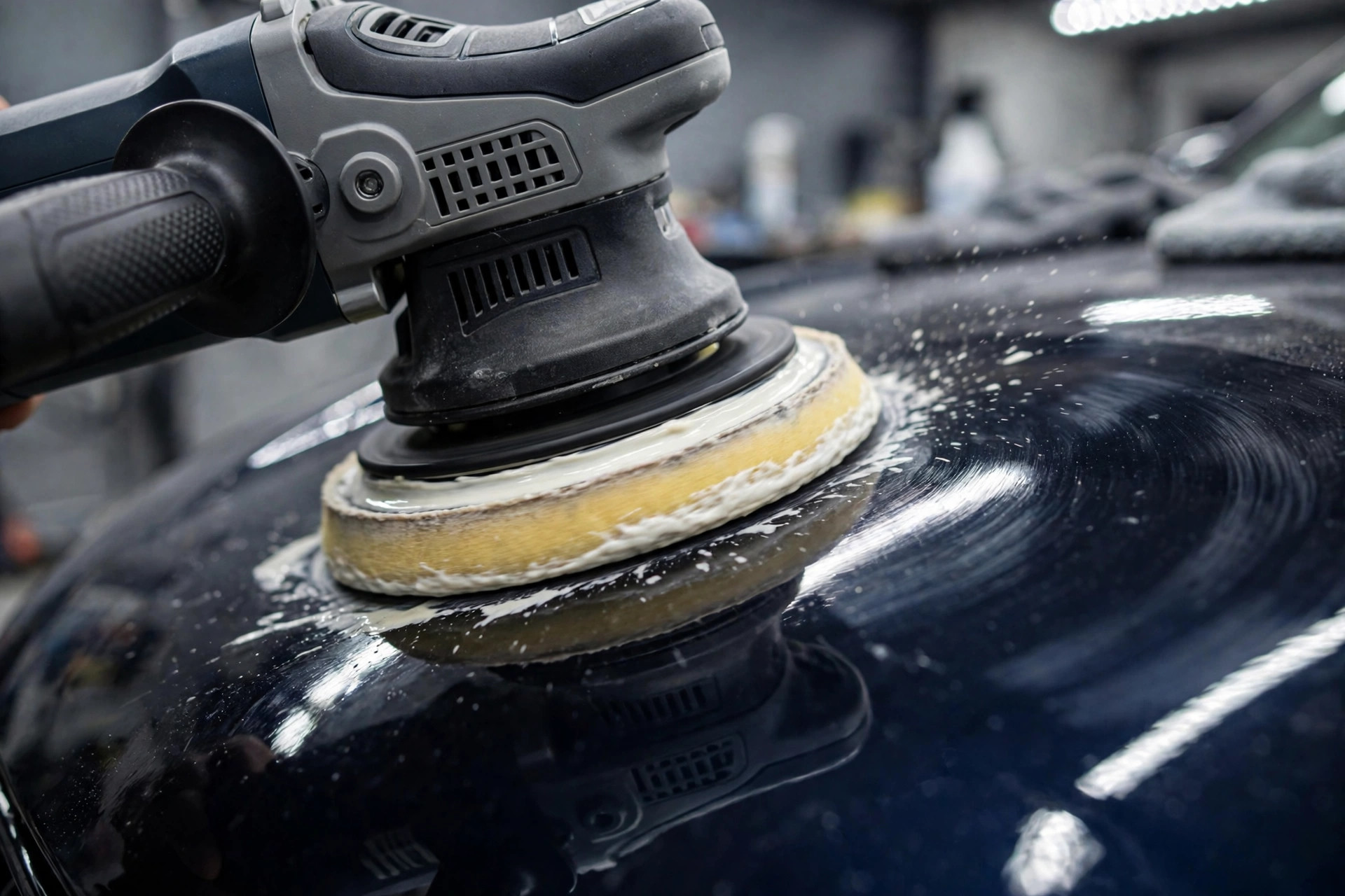 Dual-action polisher refining car paint to a mirror gloss