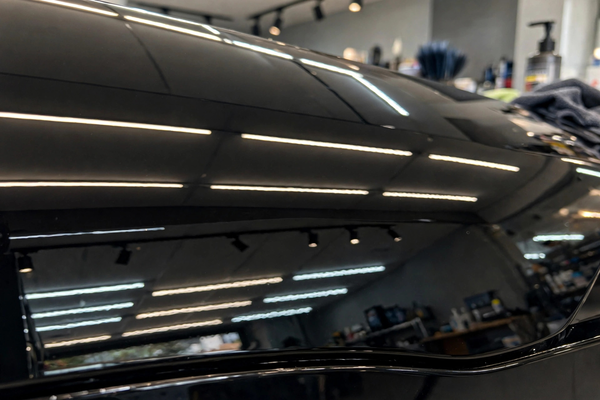 Black car paint after professional paint correction, deep mirror reflections