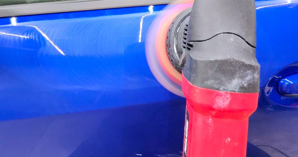 Machine polishing blue paint during paint correction at Vinnie's Auto Detailing